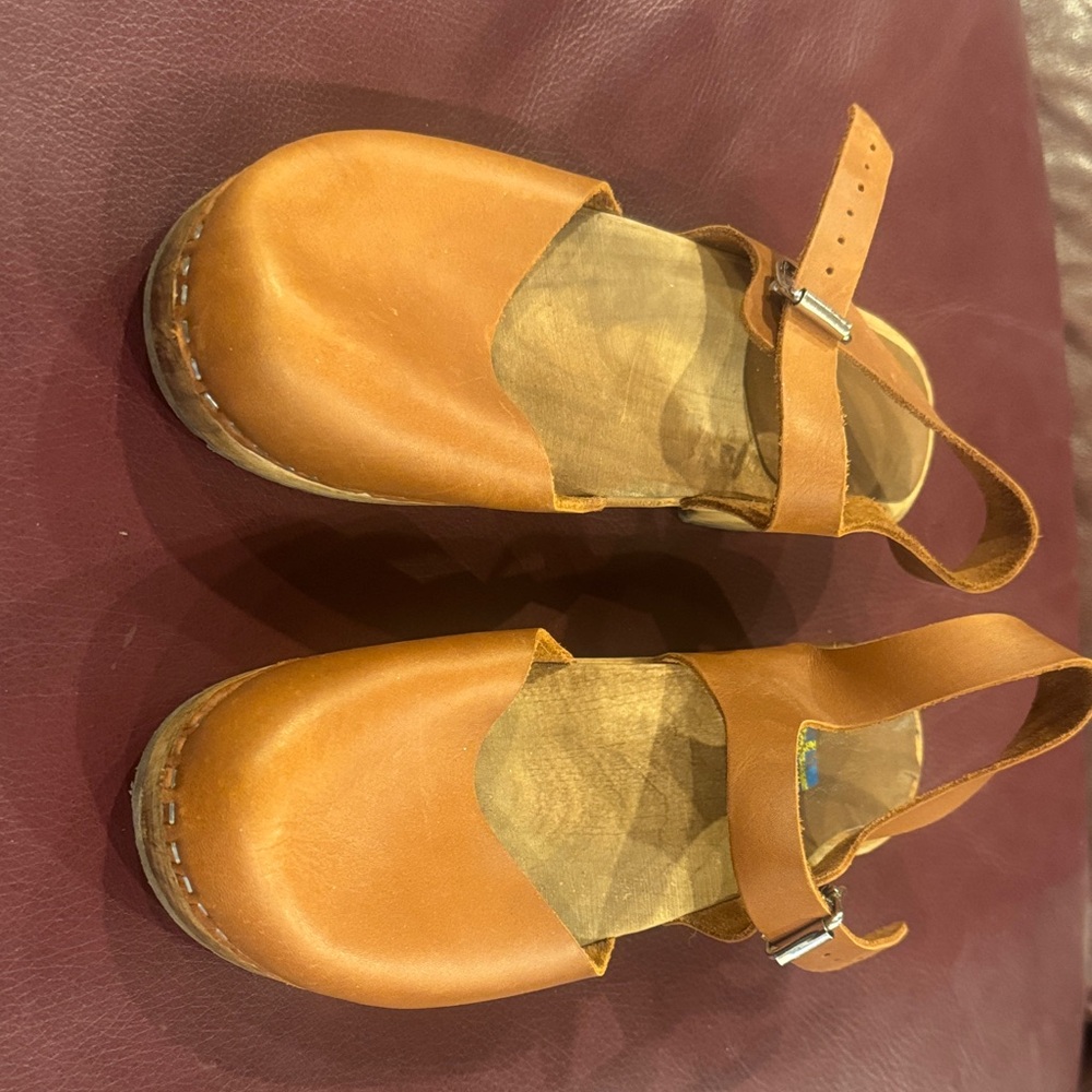 Brown leather clogs.